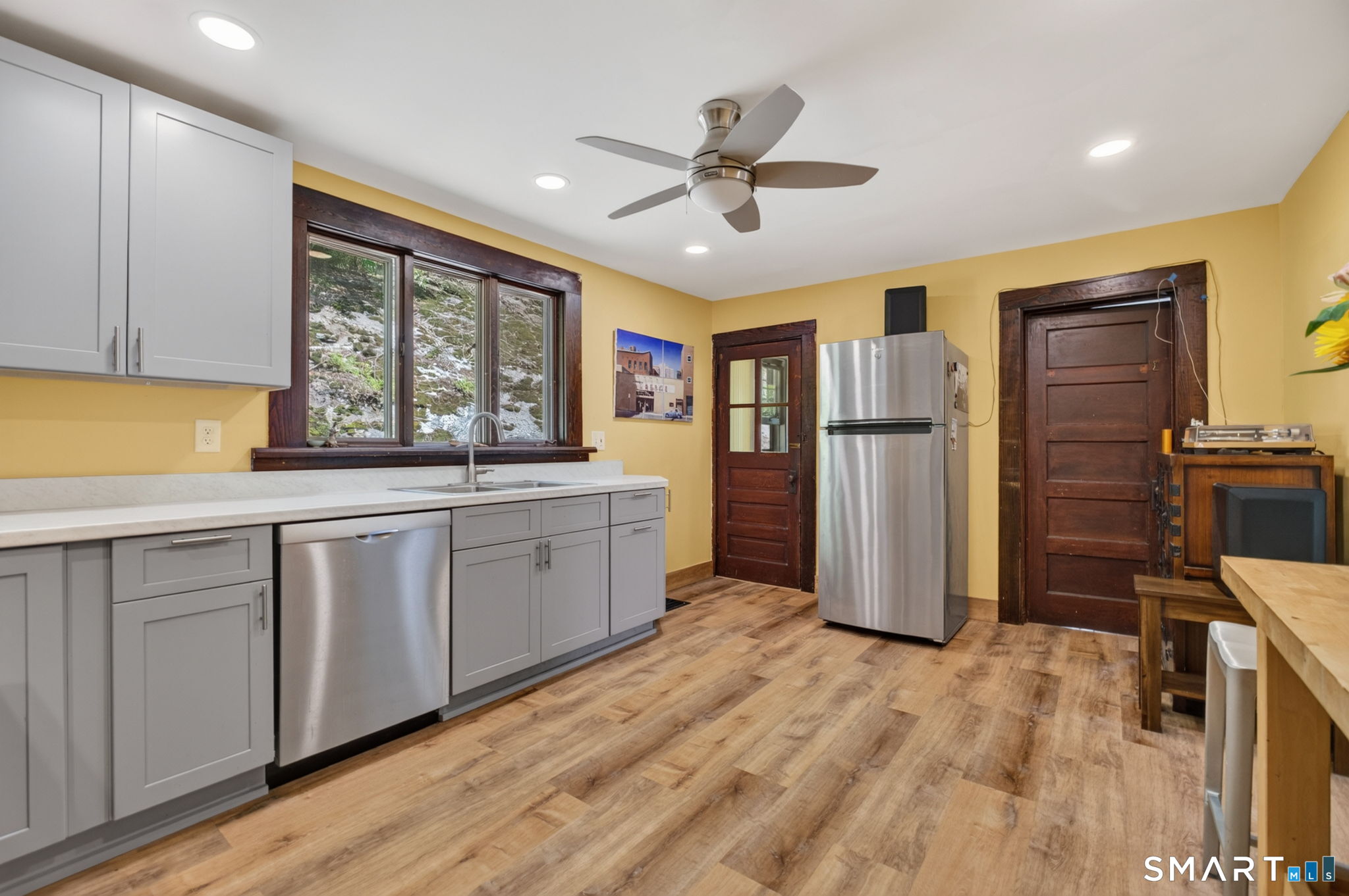 79 River Street Deep River, CT 06417 - Photo 17 of 40 a kitchen with stainless steel appliances granite countertop a refrigerator a sink and white cabinets with wooden floor
