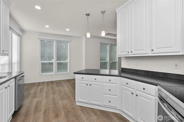 a kitchen with granite countertop white cabinets and a hard wood floors