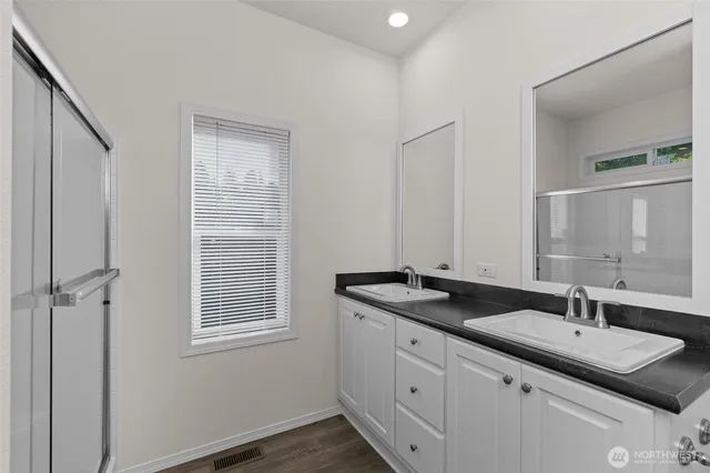 a bathroom with double sink and a mirror