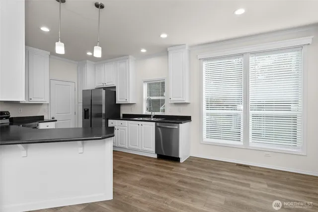 a kitchen with kitchen island granite countertop a sink cabinets and stainless steel appliances