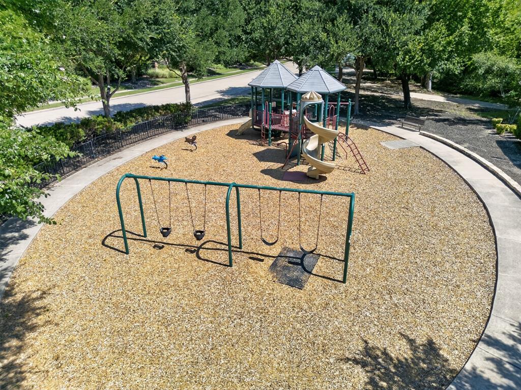 842 Sun Meadow Road Allen, TX 75013 - Photo 36 of 39 Community playground featuring multiple slides, swings, and climbing structures on a wood chip surface