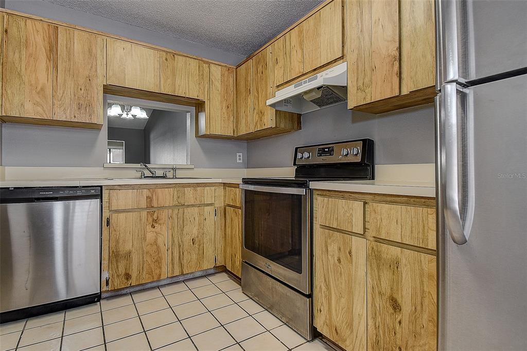4752 Sunny Loop, Unit 4752 Holiday, FL 34690 - Photo 13 of 28 a kitchen with stainless steel appliances granite countertop a refrigerator a stove a sink and dishwasher