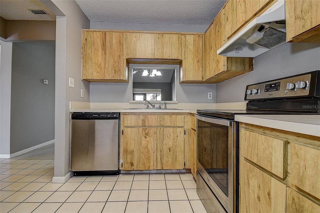 4752 Sunny Loop, Unit 4752 Holiday, FL 34690 - Photo 14 of 28 a kitchen with a sink a stove and cabinets