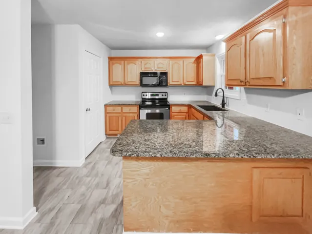 a kitchen with stainless steel appliances granite countertop a sink stove and refrigerator