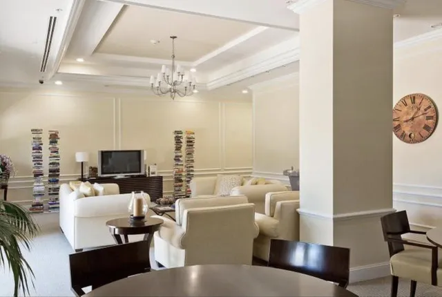 a living room with furniture a chandelier and a flat screen tv
