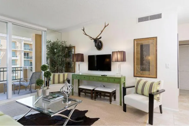 a living room with furniture a flat screen tv and a large window