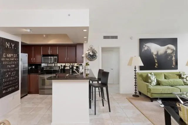 a living room with stainless steel appliances kitchen island granite countertop furniture and a view of kitchen