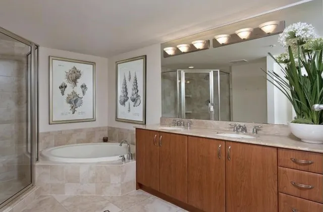 a bathroom with a granite countertop sink a large mirror and a bathtub