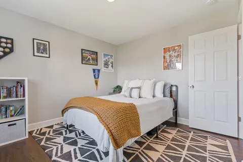a bedroom with a bed a chair and a large window