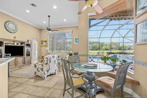 a living room with furniture large windows and wooden floor