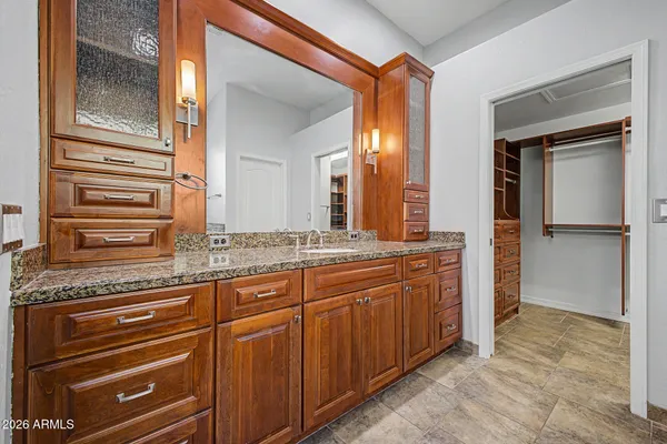 a spacious bathroom with a granite countertop sink and a mirror
