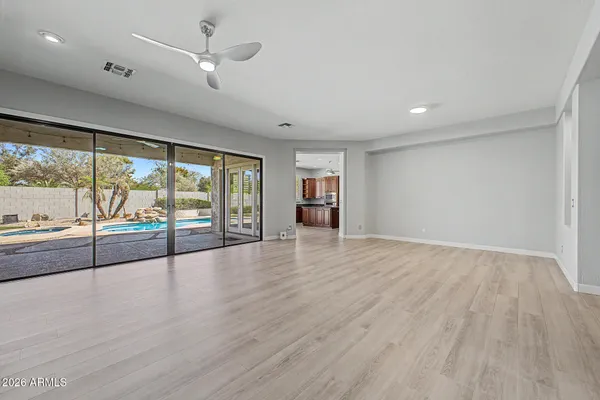 a view of an empty room with wooden floor and a window