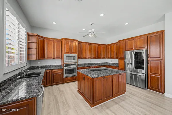 a kitchen with stainless steel appliances granite countertop a stove a sink and a refrigerator