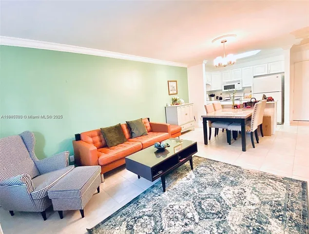 a living room with furniture a dining table and a refrigerator