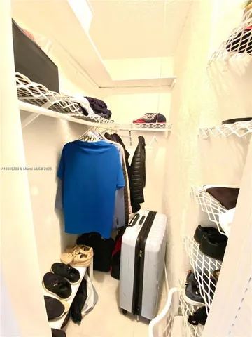 a view of walk in closet with clothes and shoes