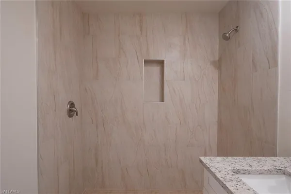 a bathroom with a granite countertop sink and white cabinets