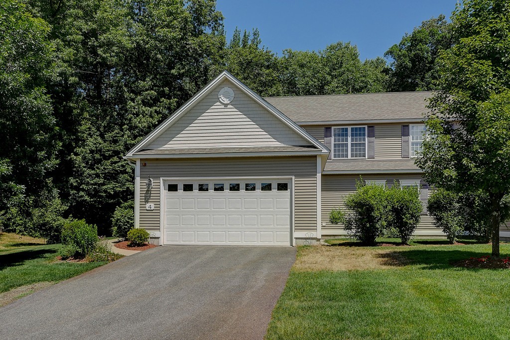 4 Old Stage Road, Unit 4 Litchfield, NH 03052 - Photo 1 of 30 a front view of a house with a yard and garage