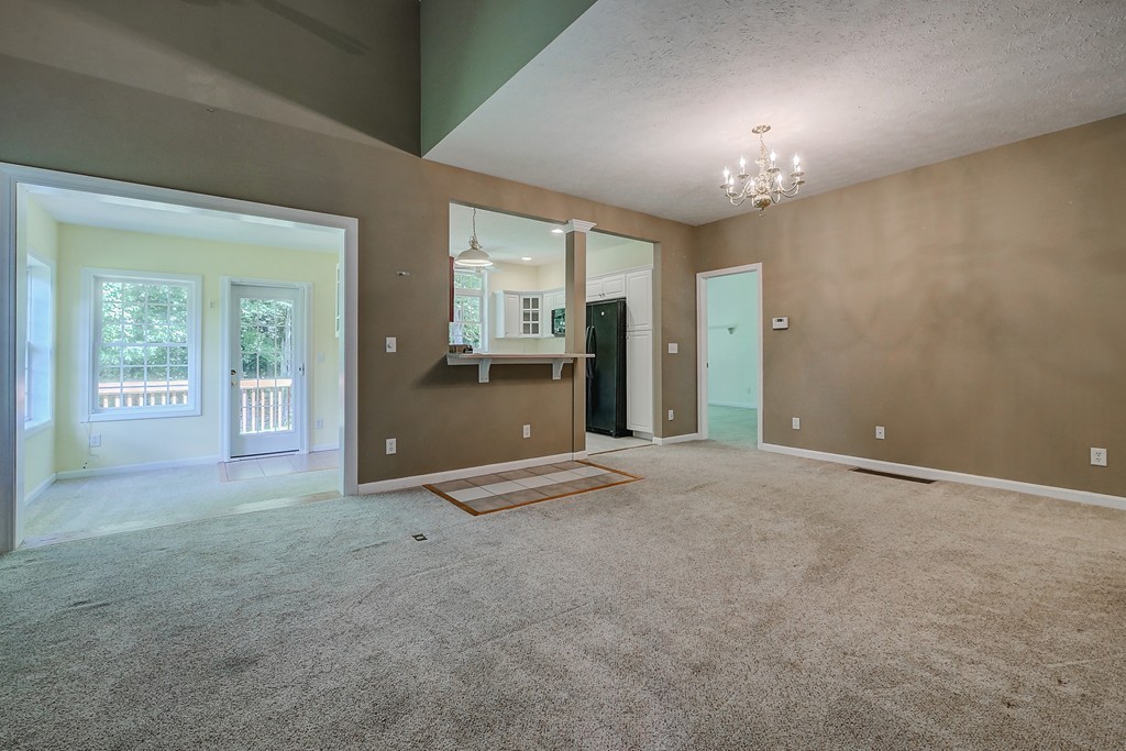 4 Old Stage Road, Unit 4 Litchfield, NH 03052 - Photo 7 of 30 an empty room with chandelier and glass door