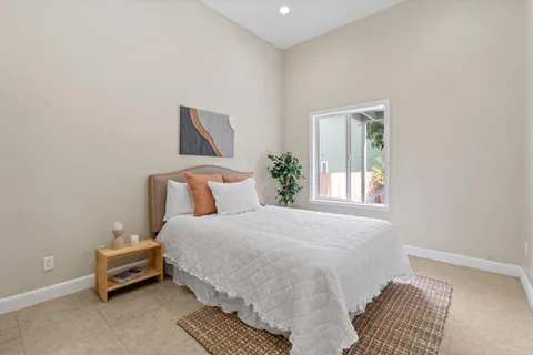 a bedroom with a bed and a potted plant