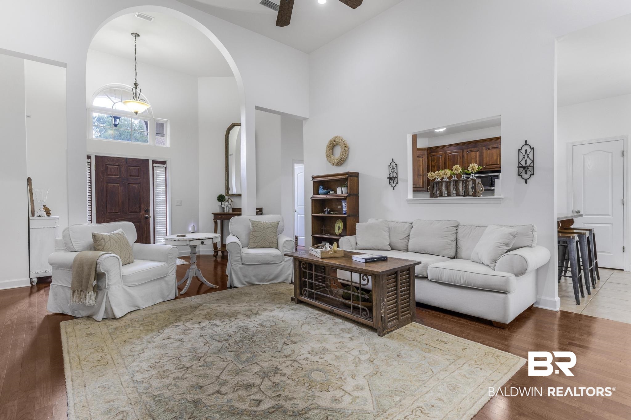 35814 Delvan Lane Bay Minette, AL 36507 - Photo 13 of 53 Spacious living area featuring wood-finish flooring, high vaulted ceilings, and an arched entryway