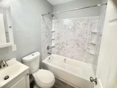 a white bath tub sitting next to a white toilet and sink