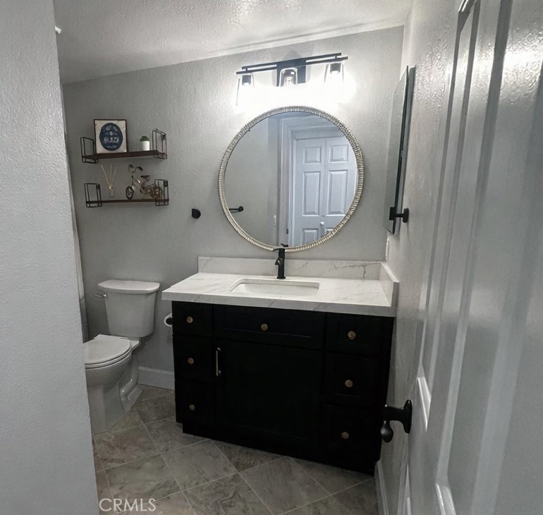 34112 Selva Road, Unit 336 Dana Point, CA 92629 - Photo 16 of 18 a bathroom with a sink a toilet and a mirror