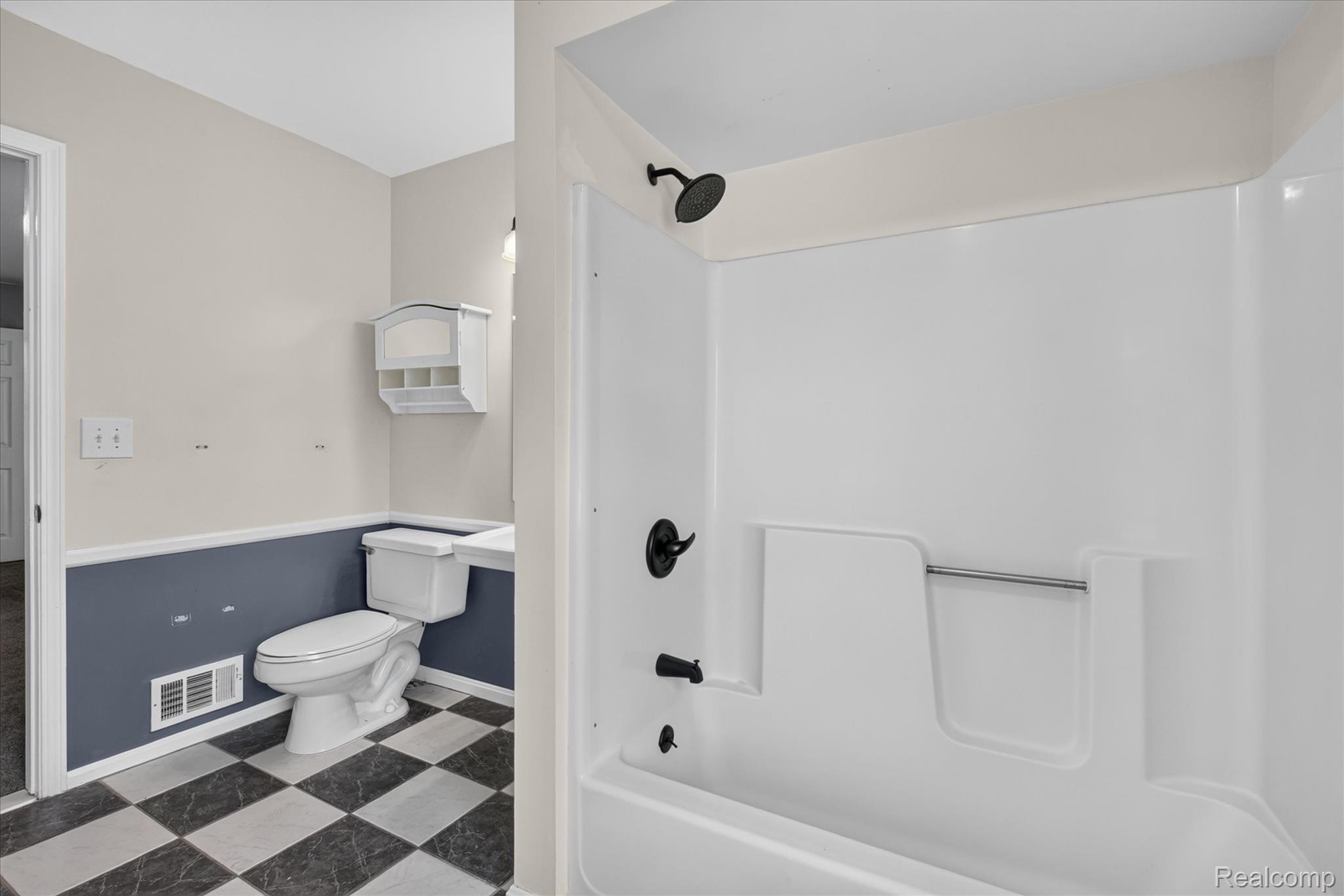 8114 Chilson Road Pinckney, MI 48169 - Photo 16 of 32 Shower and toilet area featuring a white shower/tub combination with matte black fixtures