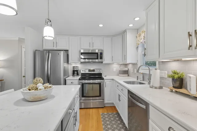 a large white kitchen with a large window