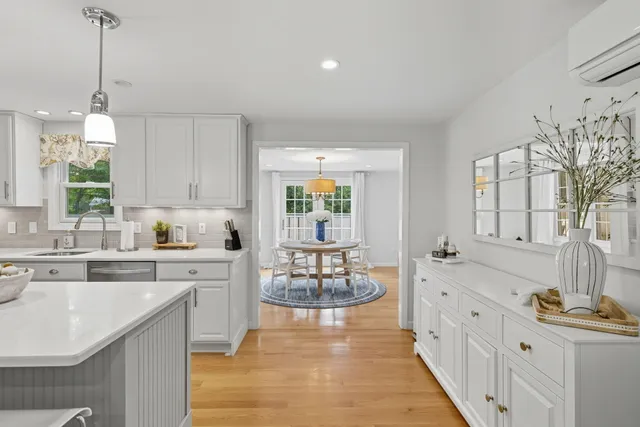 a dining room with furniture a chandelier and wooden floor
