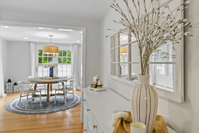 a view of a dining room with furniture a chandelier and wooden floor