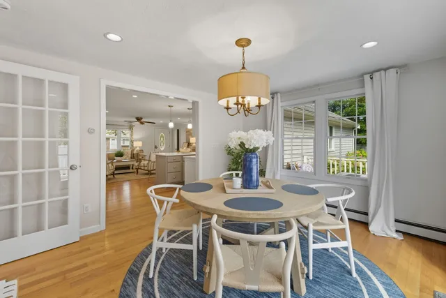 a view of a room with wooden floor table and chairs