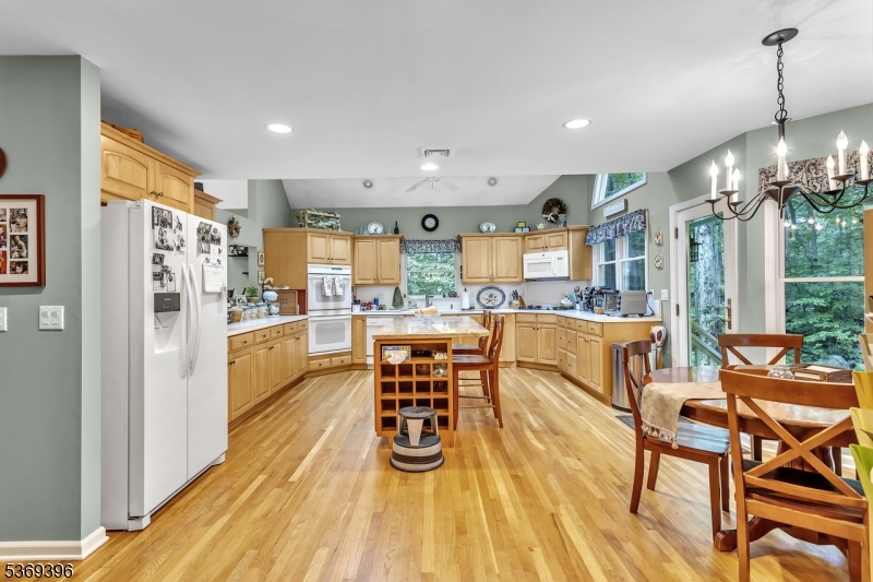 18 Hickory Run Road Califon, NJ 07830 - Photo 10 of 32 a kitchen with stainless steel appliances kitchen island granite countertop a refrigerator a stove a dining table and chairs with wooden floor