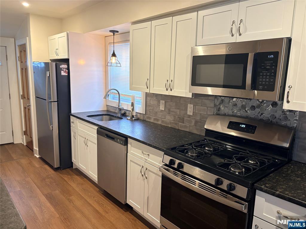 40 Poplar Avenue, Unit 1 Hackensack, NJ 07601 - Photo 3 of 9 a kitchen with stainless steel appliances a stove a microwave a sink and cabinets