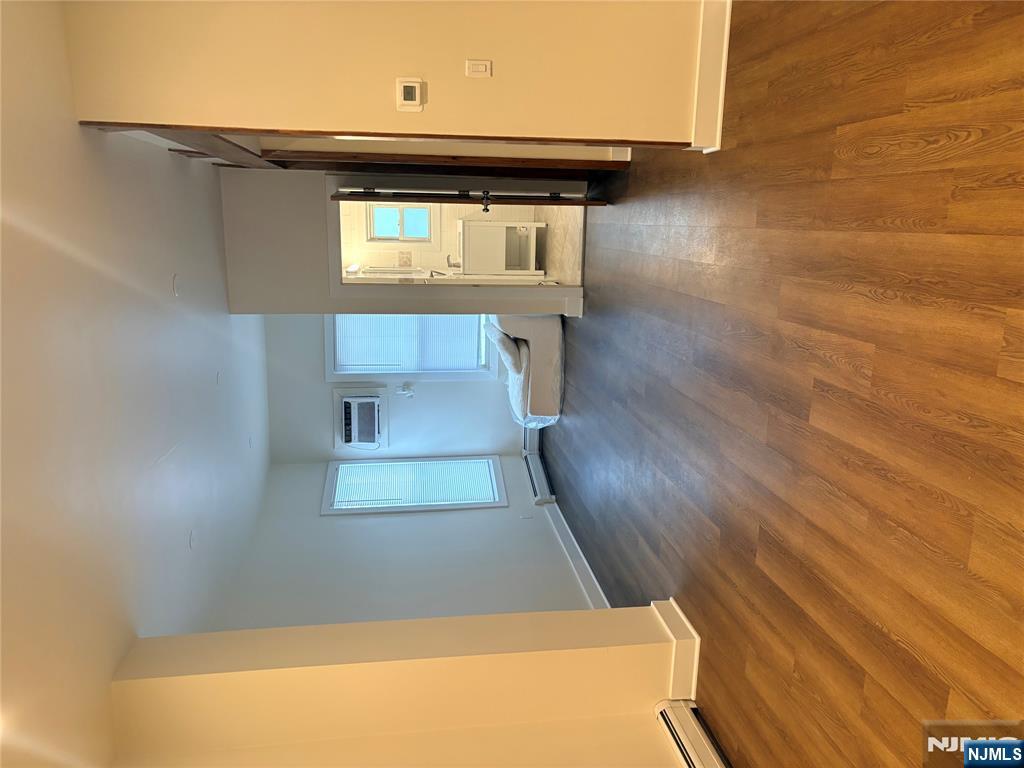 40 Poplar Avenue, Unit 1 Hackensack, NJ 07601 - Photo 5 of 9 an empty room with wooden floor and windows