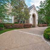 a front view of a house with a garden and trees
