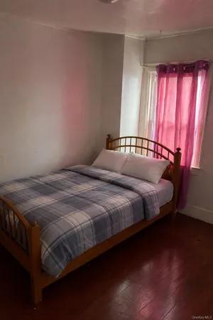 a bed sitting in a bedroom next to a window