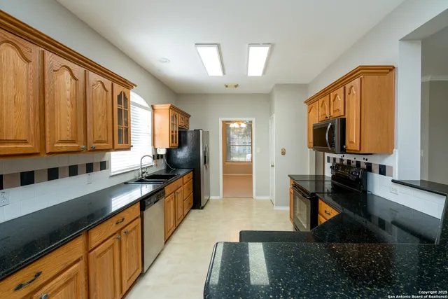 a kitchen with stainless steel appliances granite countertop a sink stove and cabinets
