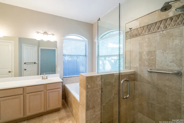 a spacious bathroom with a double vanity sink a mirror a shower and a bathtub