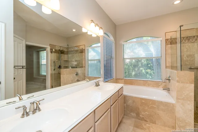 a spacious bathroom with a tub sink and mirror