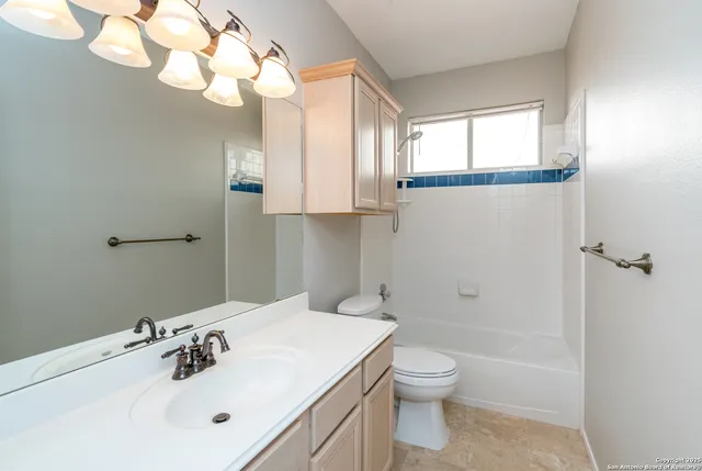 a bathroom with a toilet a sink a mirror and a shower