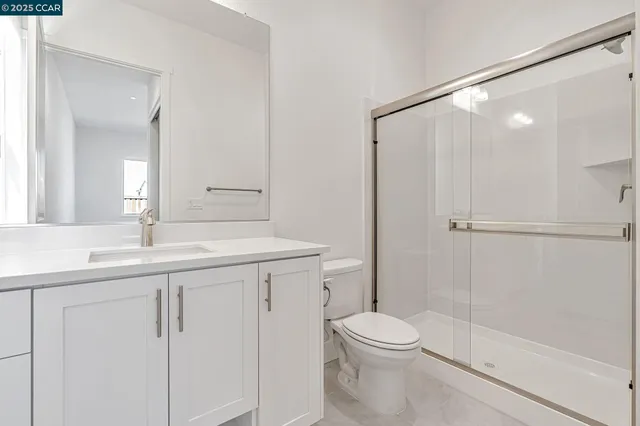 a bathroom with a sink a toilet a shower and a mirror