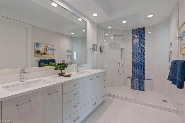 a bathroom with a double vanity sink and shower