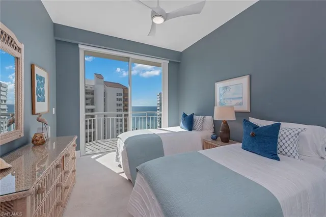a bedroom with two beds and a large window