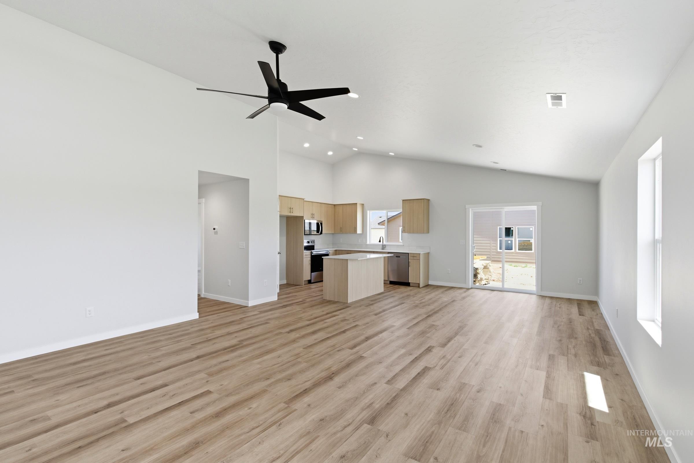 8317 South Tyrion Way Kuna, ID 83634 - Photo 8 of 22 Expansive living area featuring vaulted ceilings, wood-finish flooring, and a modern ceiling fan