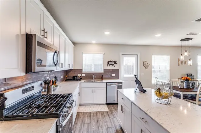 a kitchen with a sink a stove and cabinets