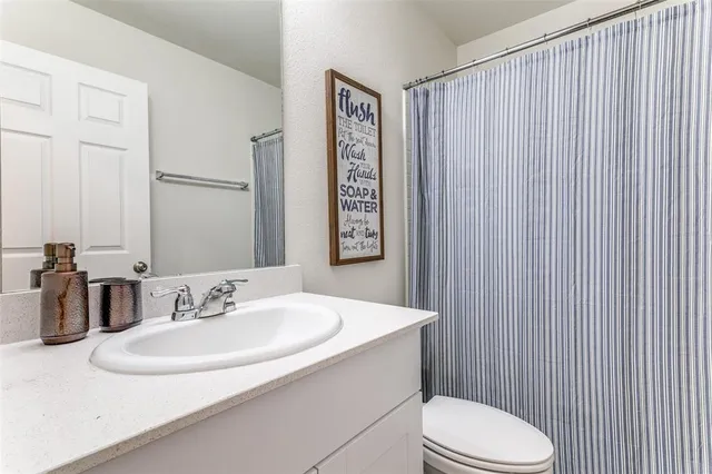 a bathroom with a sink a toilet and mirror