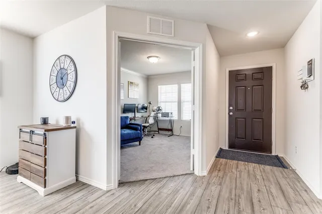 a view of a hallway with wooden floor and furniture