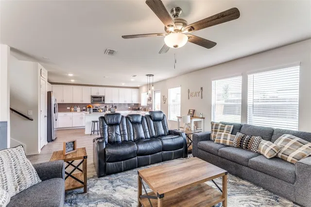 a living room with furniture ceiling fan and a window