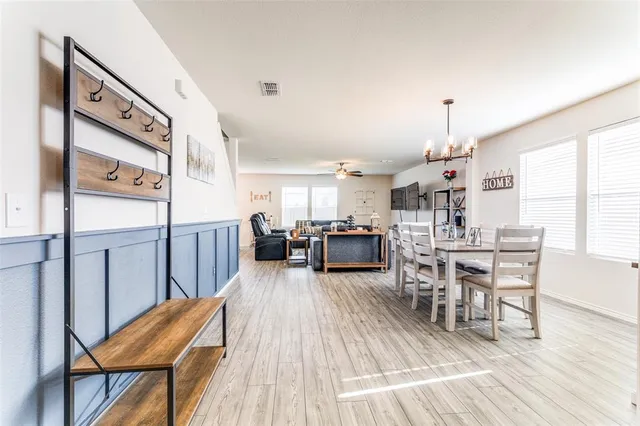 a living room with furniture a wooden floor and next to a window