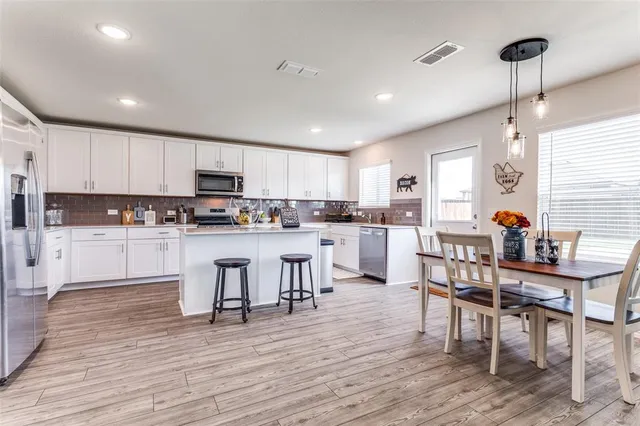 a kitchen with white cabinets and stainless steel appliances